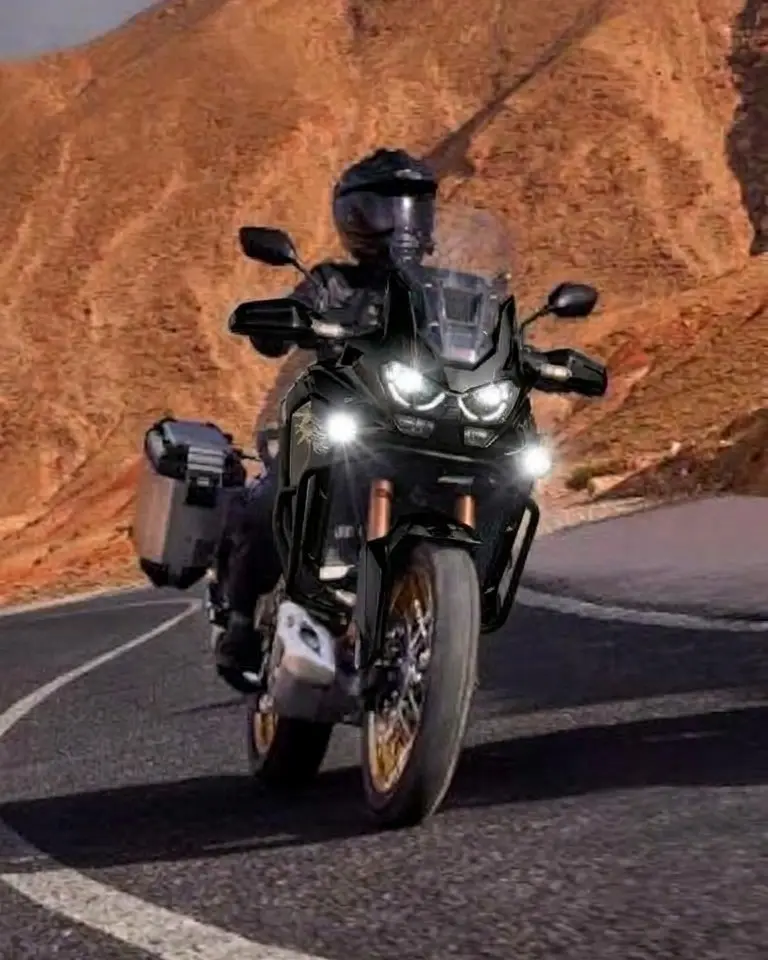 Black motorbike with side cases on a mountain road.